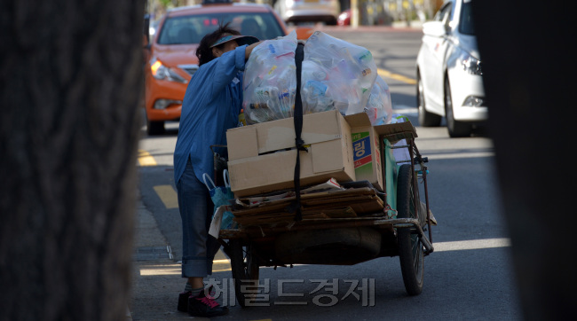 청년실업과 장년층의 은퇴에 따른 생활고가 노인빈곤으로 연결되는 악순환이 이어지고 있다. 서울 용산구에서 한 노인이 한푼이라도 더 벌기위해 파지를 주워 팔고 있다. 김명섭 기자 msiron@heraldcorp.com